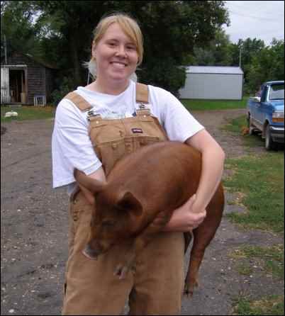 woman farmer holding red pig feminization-of-farming-in-north-america-women-farmers