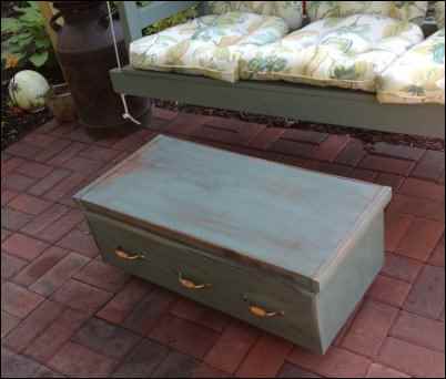 This outdoor coffee table/storage ottoman is made from an old bureau by upcycling on the homestead.  Photo by Louise LePierres